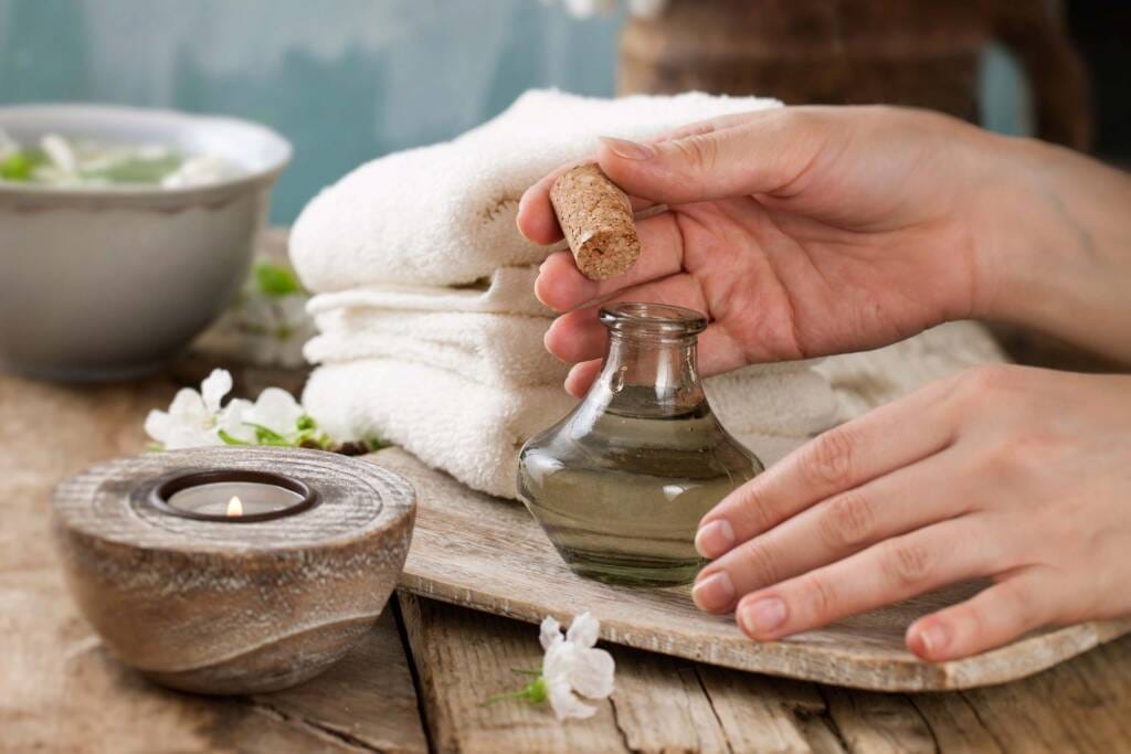 Close-up of a massage table prepared with a plush white towel and natural decor, reflecting a high standard of hygiene and comfort.