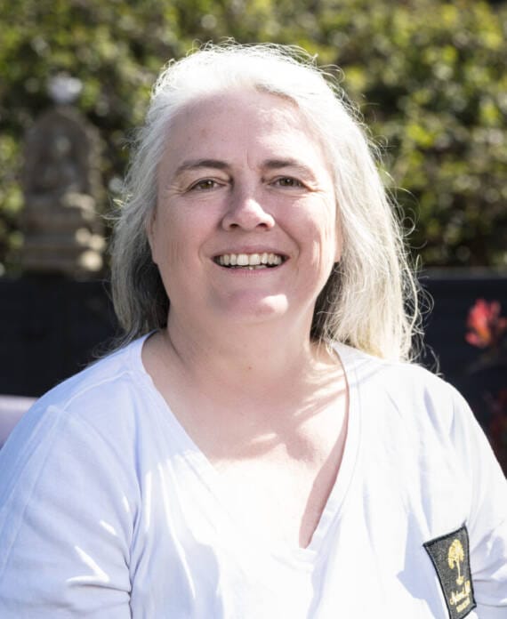 A woman lying with eyes closed while a practitioner performs energy work, featuring a "Reiki Healing" text overlay.